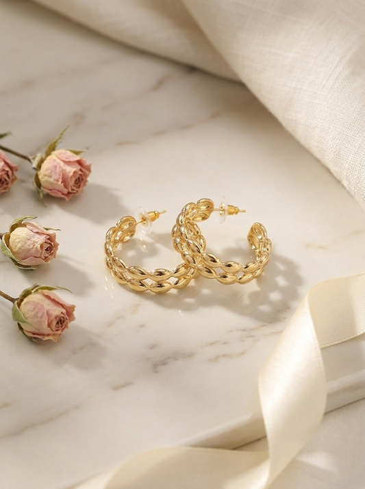 Model wearing gold twisted hoop earrings