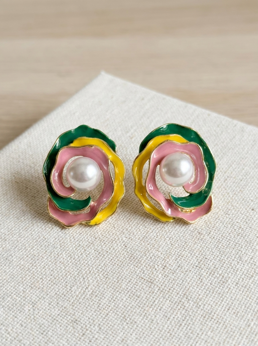 Enamel rose pearl stud earrings on linen fabric close-up