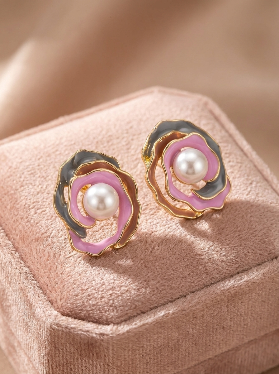 Pink and grey enamel rose pearl stud earrings on cream satin fabric flat lay
