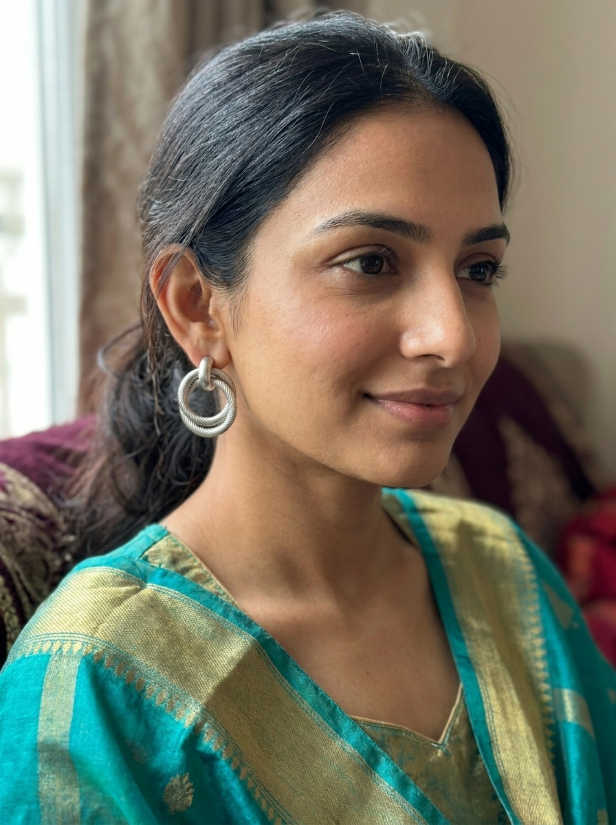 Model wearing silver twisted double hoop earrings with teal silk kurta