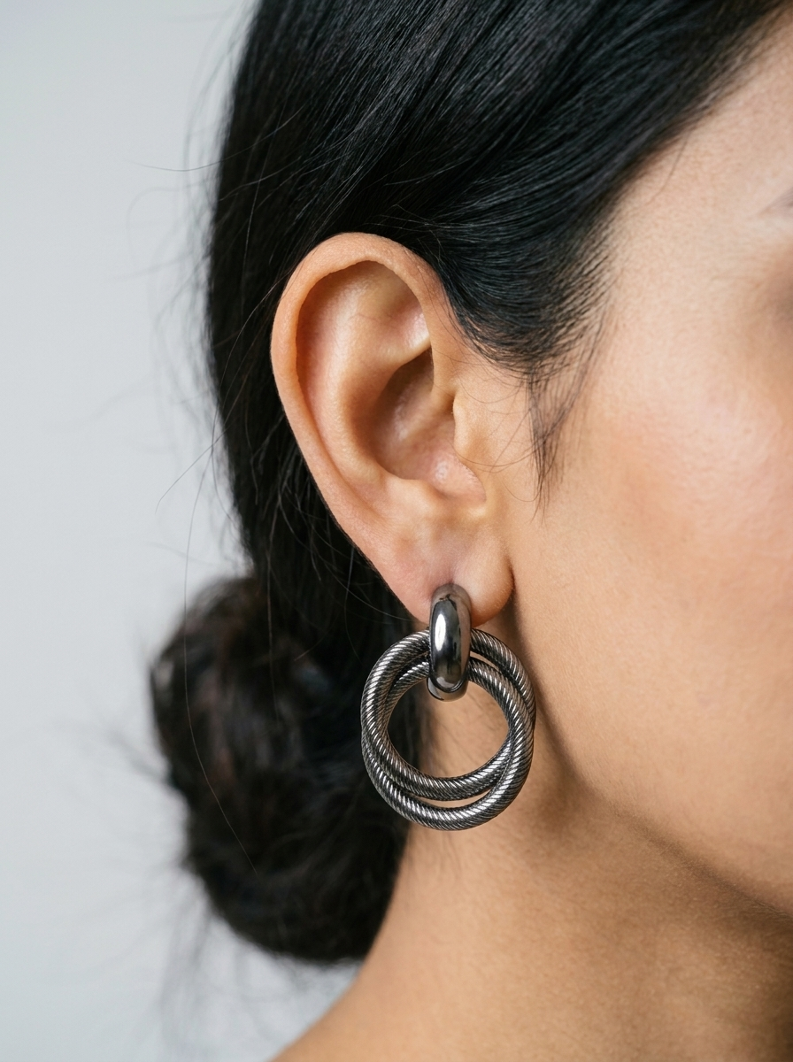Close-up of gunmetal twisted double hoop earring worn on ear